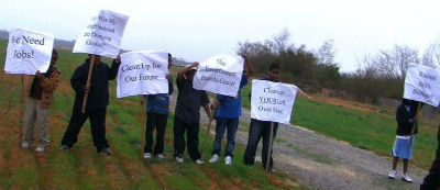 Residents of Navassa greeted an anti-poverty group in 2012 with signs about the old Kerr-McGree site. Photo: Cash Michaels