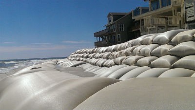 The sand structures in in front of the sand-bag wall at North Topsail violate the state permit and must be removed, state official say. Photo: Frank Tursi