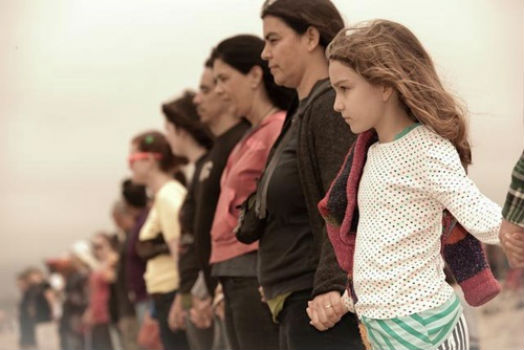 Residents of Santa Monica stand together holding hands as part of a demonstration against fossil fuels. There will be several such events, known as Hands Across the Sand, this Saturday across North Carolina. Photo: Nancy Smith