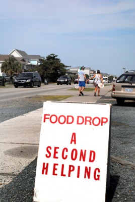 It’s leaving time at Holden Beach, and a line of departing cars – plus a hand-holding couple – form a backdrop for Second Helping’s food collection. Photo: Hannah Miller