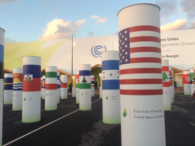 Pillars at the conference entrance, each decorated with a different national flag, illustrate the sense of unity in the global mission to stem global warming. Photo: Cate Kozak