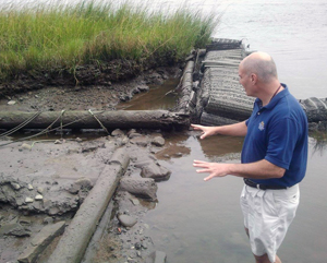 Jim McKee explores the eroded shoreline at the Brunswick Town Historic Site. Photo: State Port Pilot 