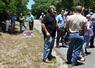 The tour group stops to examine a swale used to capture stormwater at Oak Island. Photo: Todd Miller