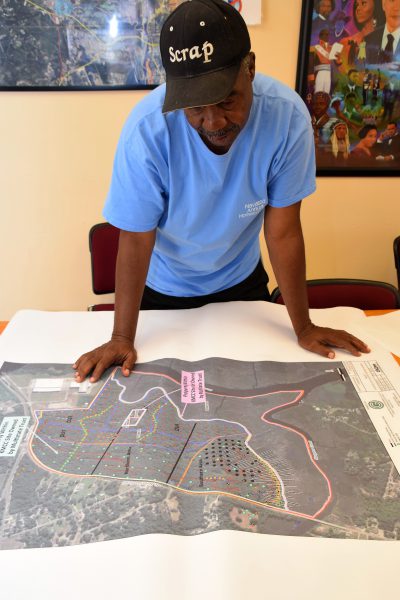 Mayor Eulis Willis looks over an aerial photo showing contaminated sites in Navassa. Photo: Mark Hibbs