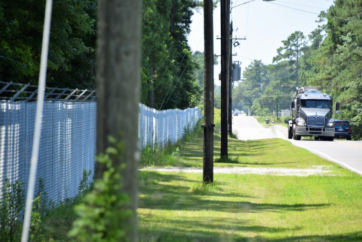 Traffic passes by the fenced-off Kerr-McGee Chemical Corp. site that’s just off the highway leading into Navassa. File photo: Mark Hibbs