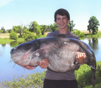 Benson angler Landon Evans, 15, holds a state record-breaking blue catfish – a 117-pound, 8-ounce fish, caught from Lake Gaston on June 11. Photo: North Carolina Wildlife Resources Commission