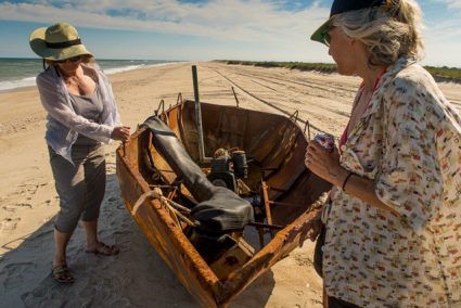 Tinka Jordy, left, and Pat Arnow examine the inboard engine and the rubber inner tube used for floatation. Photo: Joanie Alexander