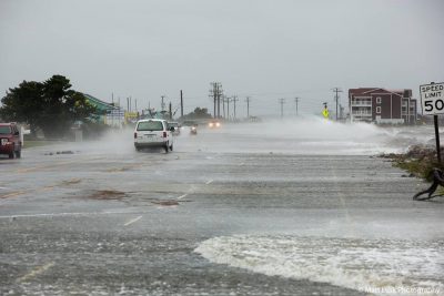 Vehicles pass as water rises on the U.S. 64 causeway near Whalebone Junction. Photo: Matt Lusk Photography