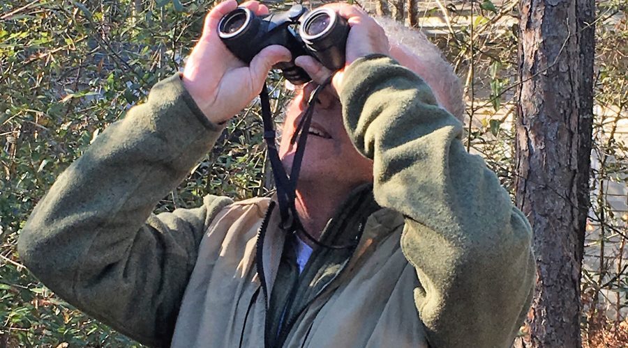 John Fussell uses his binoculars to get a closer look when birding in this 2017 photo by Brad Rich.