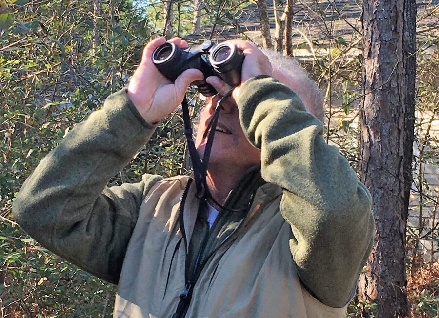 John Fussell uses his binoculars to get a closer look when birding in this 2017 photo by Brad Rich.