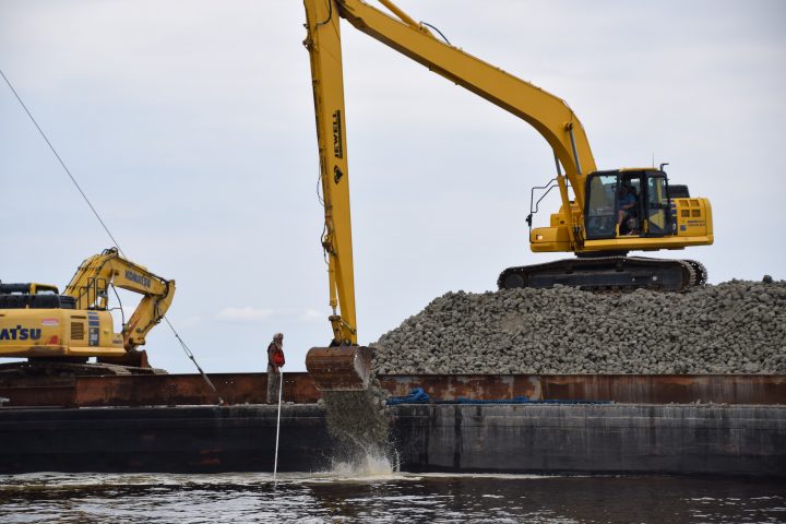 A crew with Stevens Towing Co. places oyster reef base material, limestone marl riprap, at the site of an oyster sanctuary in Pamlico Sound in 2017. File photo: Mark Hibbs