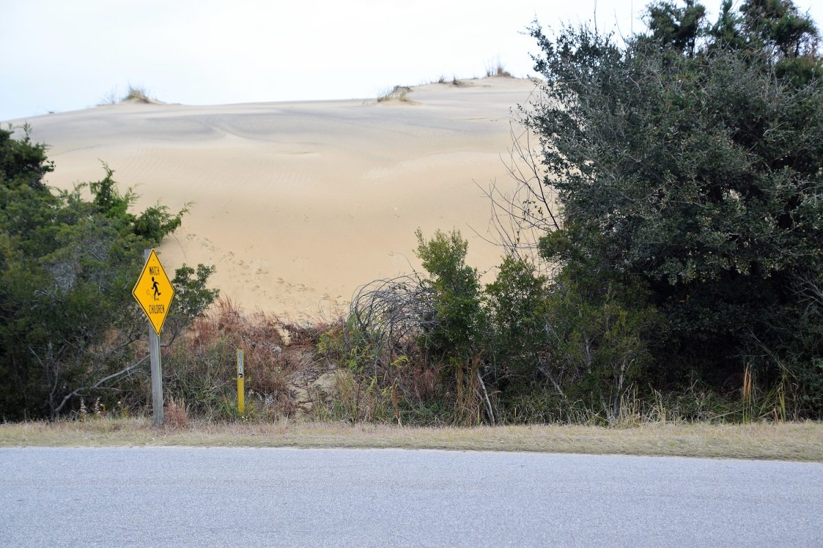 The constantly migrating dunes at Jockey's Ridge State Park encroach Soundside Road just outside the park in this 2019 photo by Mark Hibbs