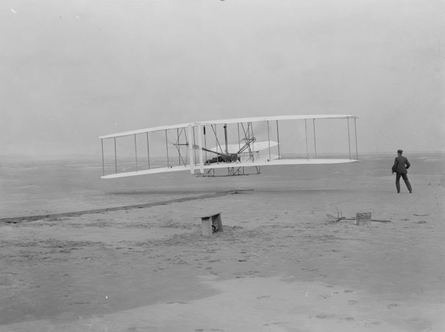 Orville Wright takes off in the first flight of the 1903 flyer as Wilbur Wright assists. Photo: National Park Service 