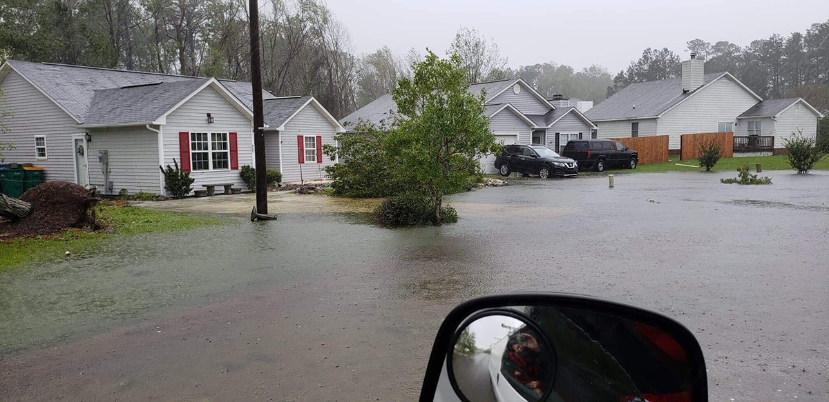 Mark and Zena Underwood's house, gray with red shutters, is shown as water approaches during Hurricane Florence in 2018. They have since relocated and received state assistance toward a new home via a program that also took the property above off the market. Photo: Zena Underwood