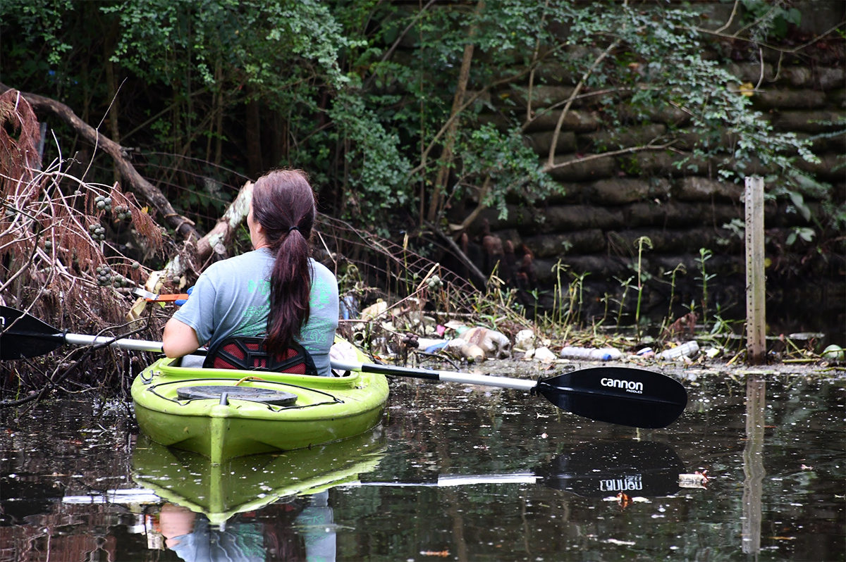 A paddler encounters plastic waste and other man-made debris in a tributary of Greenfield Lake in Wilmington. Photo courtesy of Cape Fear River Watch 