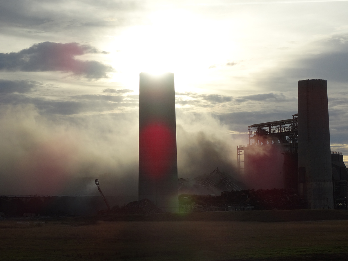 The remains of the two smokestacks at Duke Energy’s former coal-fired Sutton Plant in Wilmington loom over the demolished boiler and coal silos in 2016. Photo: Duke Energy