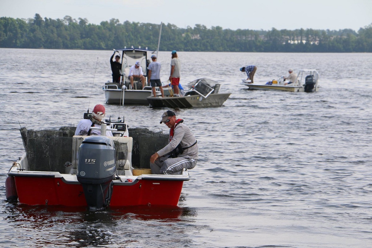 Boats manned by volunteers from Jacksonville businesses help move live oysters to the reef sites in 2019 on the New River Estuary Oyster Highway. The existing project has been named to receive an Environmental Enhancement Grant. Photo: City of Jacksonville
