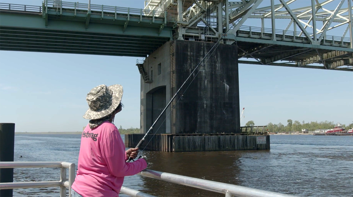 A fisher is shown near the Cape Fear Memorial Bridge in Wilmington in this screengrab from a Duke Superfund Community Engagement video. 