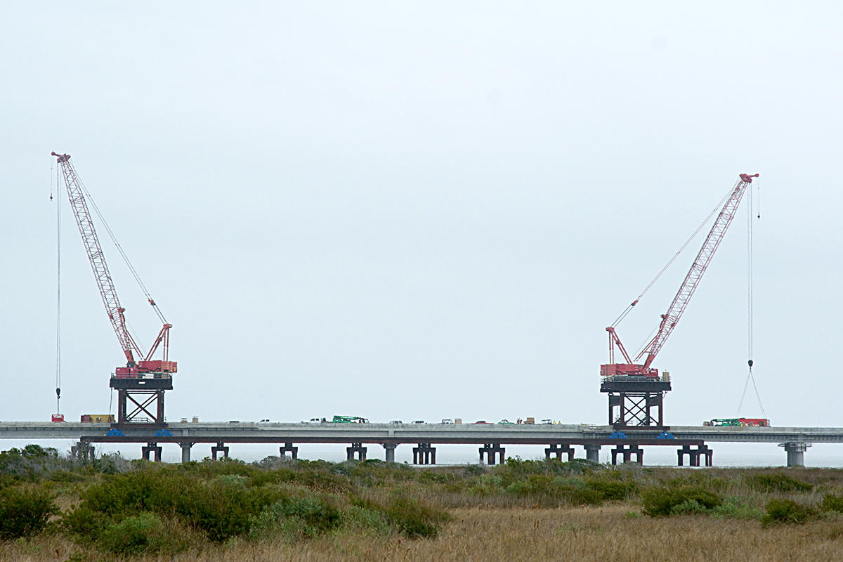 Twin cranes bookend a segment of the N.C. 12 bridge under construction Wednesday near Pea Island. The project is expected to be completed early this year. Photo: Kip Tabb 