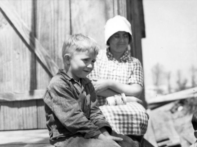 Young boy and woman, perhaps his mom, on front porch of a general store probably in Nags Head, but possibly elsewhere in Dare County, 1938-39. Photo: Charles A. Farrell, courtesy, State Archives of North Carolina 