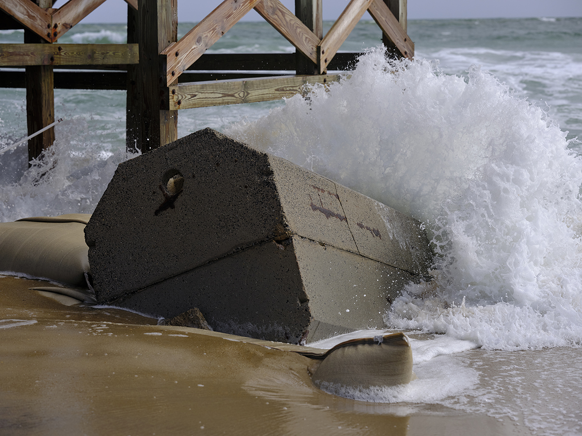 Surf breaks against an exposed septic tank off Ocean Drive in Rodanthe, Friday, March 4, 2022. Photo: Justin Cook
