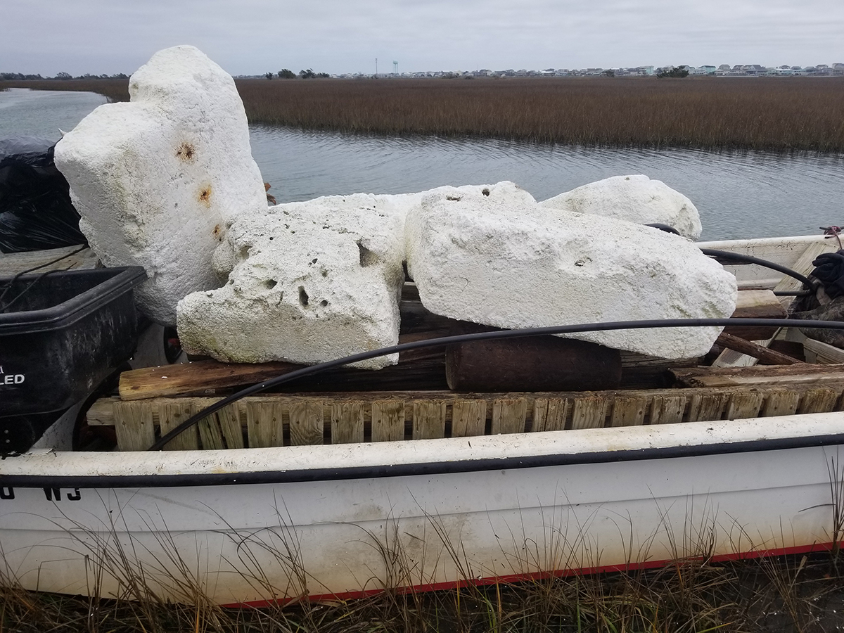 Debris from a destroyed wharf, including polystyrene, is carried aboard a boat after being picked up by a cleanup crew.  Photo: North Carolina Coastal Federation/Joe Huie