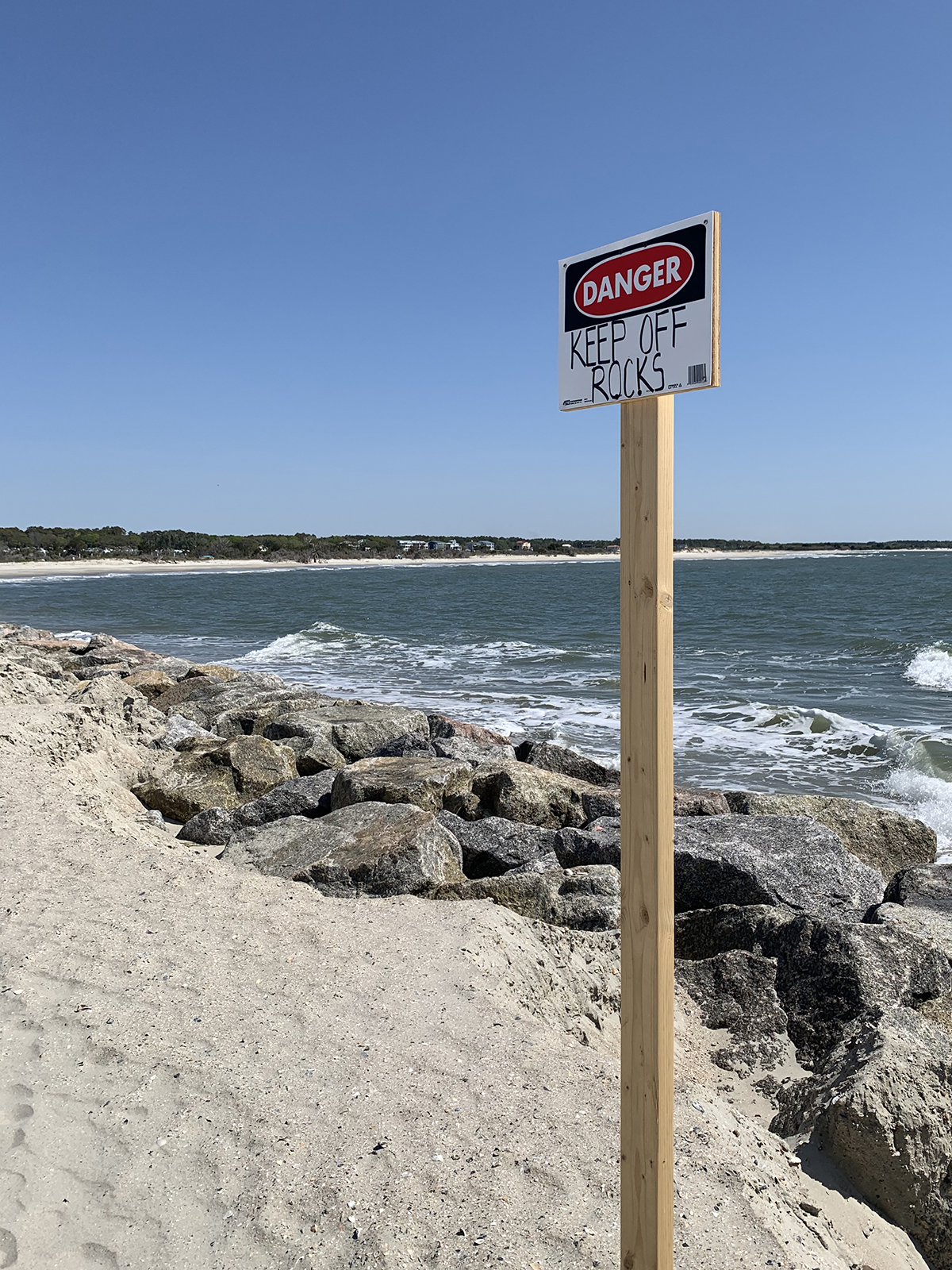 A hand-lettered signs warns beachgoers to stay off the rock portion of the structure. Photo: Trista Talton
