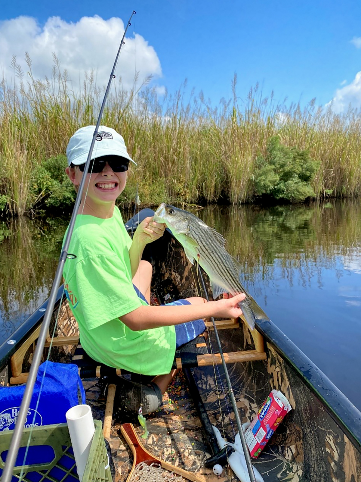 Drawing winner Harrison Bower, 9, shows off his dad Chris Bower’s yellow-tagged striped bass near Goose Creek State Park in Washington. Photo: Division of Marine Fisheries
