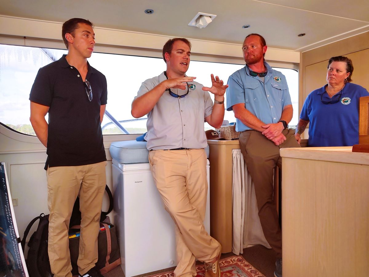 From left, Bennett Paradis, Jordan Byrum and Jacob Boyd with the Division of Marine Fisheries join Division Director Kathy Rawls to give a brief presentation Tuesday about the Cedar Island Oyster Sanctuary now under construction. Photo: Jennifer Allen