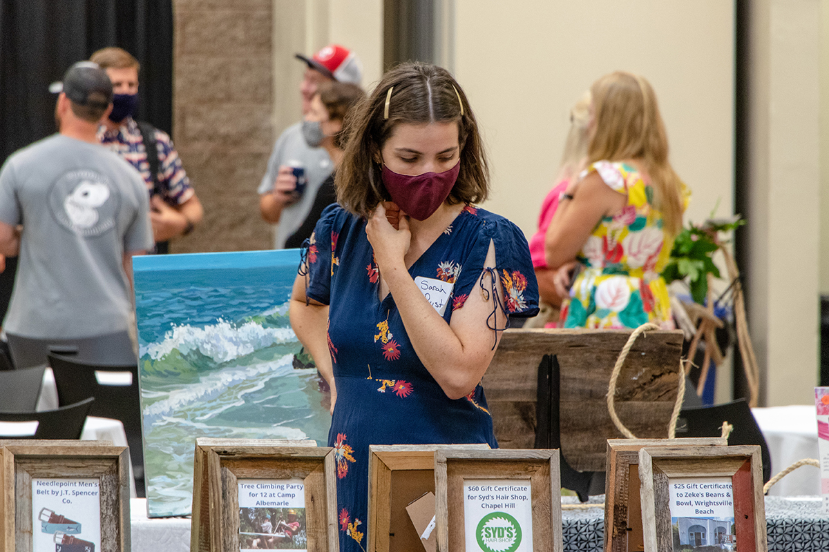 Sarah Rust peruses the silent auction items at the 2021 Pelican Awards and Toast of the Coast in Morehead City. Photo: North Carolina Coastal Federation