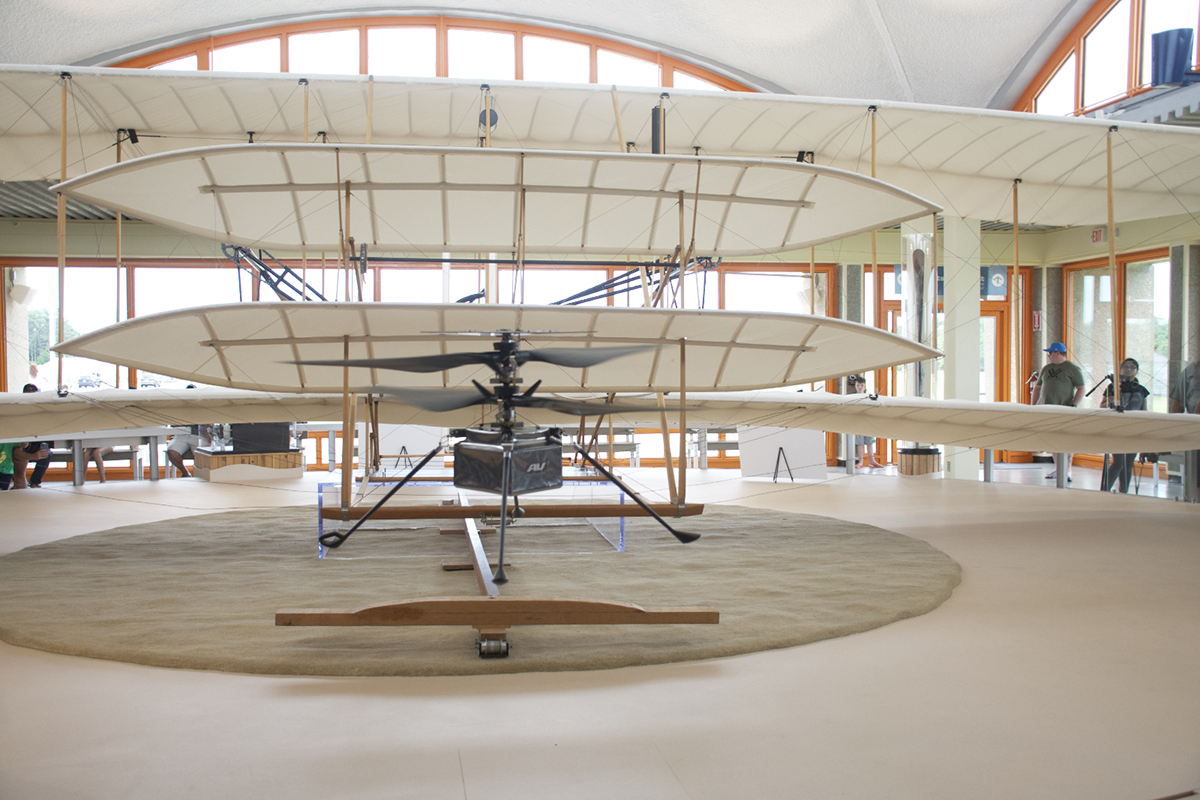 Ingenuity is shown in flight Friday in the Wright Flyer Rotunda with the Wright Flyer behind it as part of a National Aviation Day event at the national memorial in Kill Devil Hills. Photo: Kip Tabb