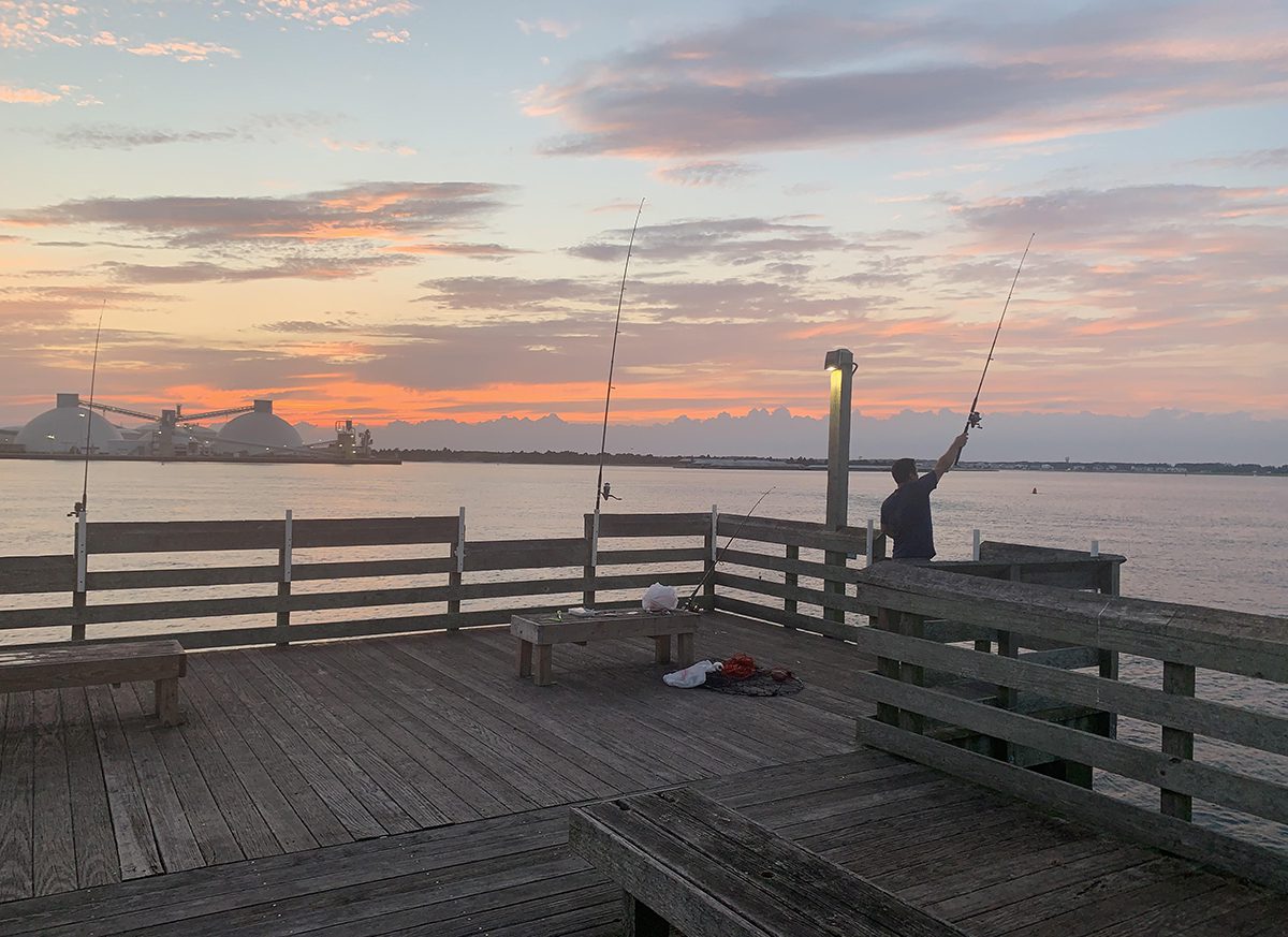 A fisher casts his line off the Newport River Pier in Morehead City. Photo: Will Atwater