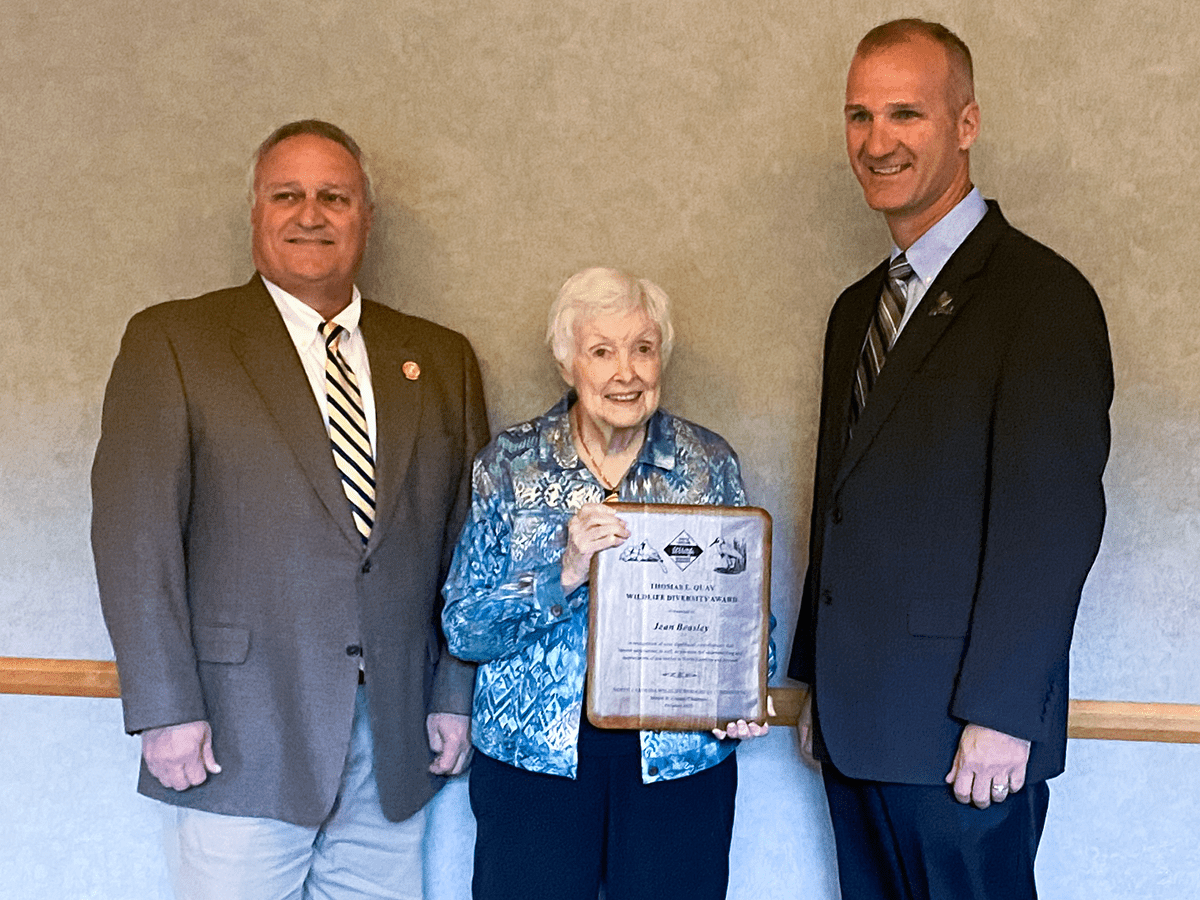 From left, Wildlife Commission Chairman Monty Crump, 2022 Quay Award winner Jean Beasley and Wildlife Commission Executive Director Cameron Ingram pose at the event in Cherokee. Photo: Courtesy the Beasley family.
