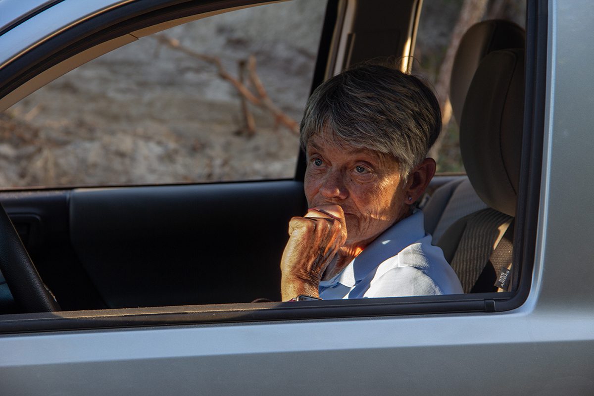 Longtime Carova resident Edna Baden stares out from her car at an empty plot of land where a forest of live oak trees used to grow. Photo: Josee Molavi