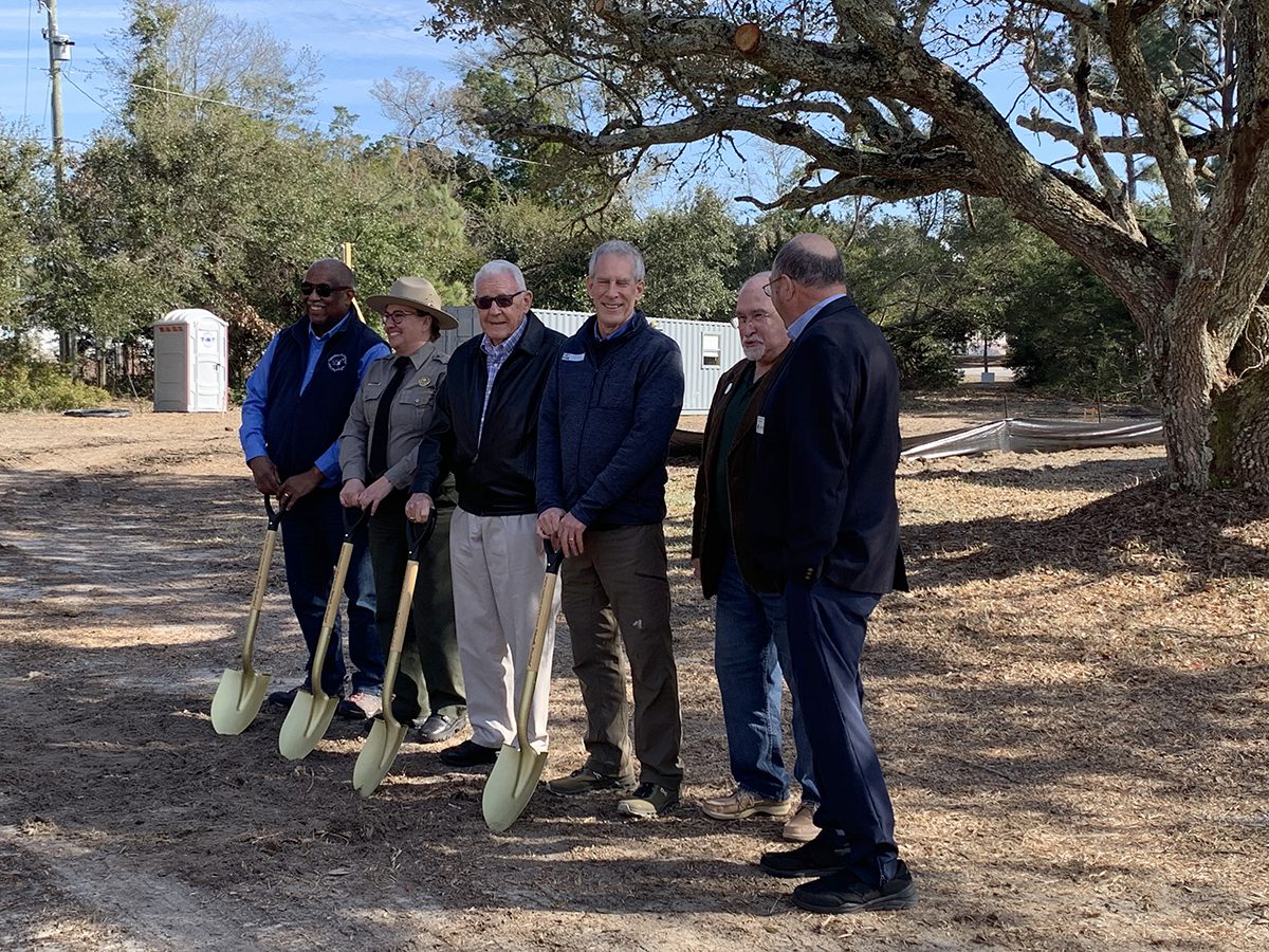 State and local officials break ground Friday at the historic teachers’ building at Hammocks Beach State Park. The building, which hosted Black educators during segregation, is being restored and transformed into a community space. Photo: Trista Talton