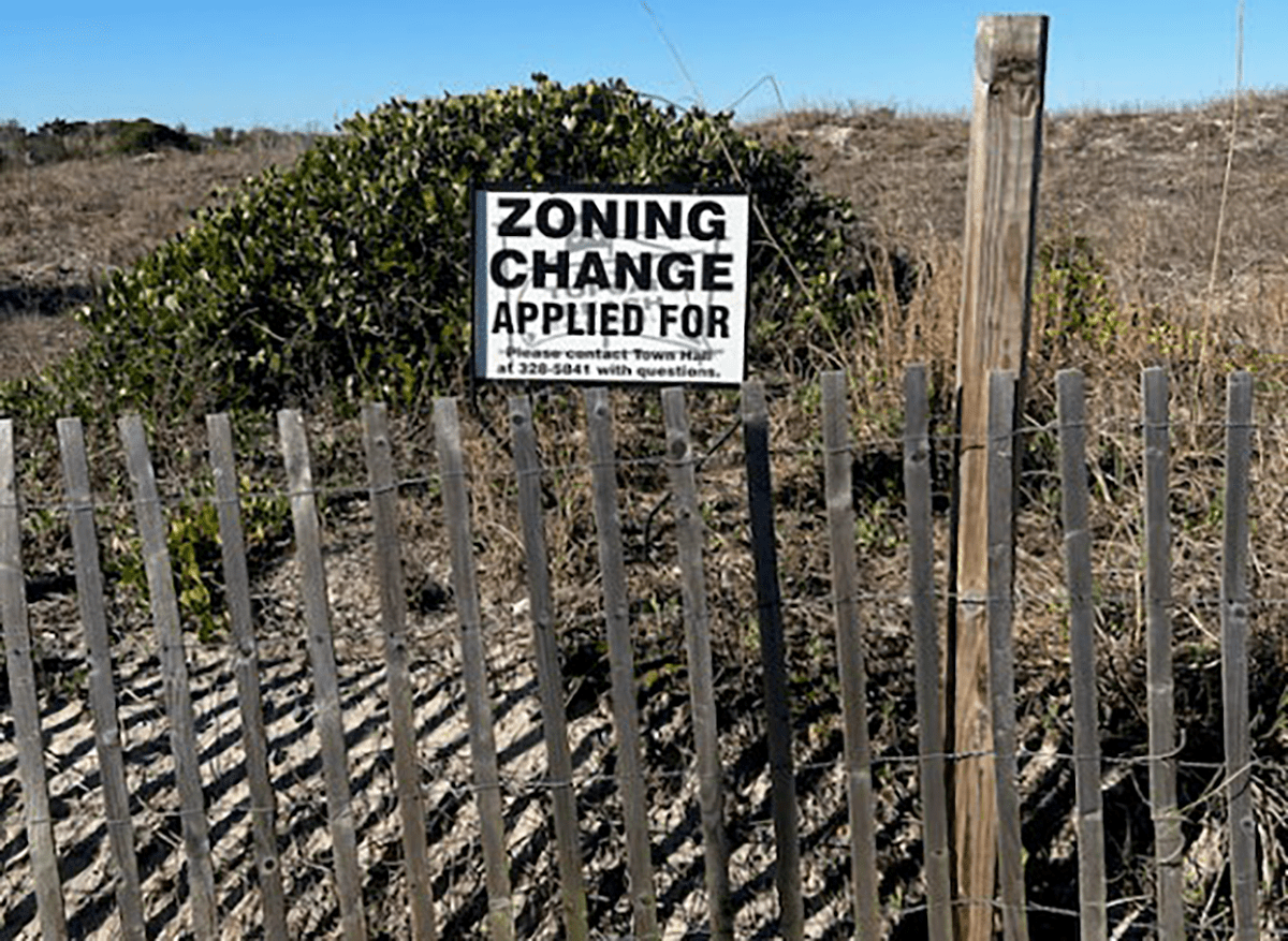 Public notice sign is shown posted on the property at what officials said was the highest point of sand beside a paid parking lot. Photo: Topsail Beach