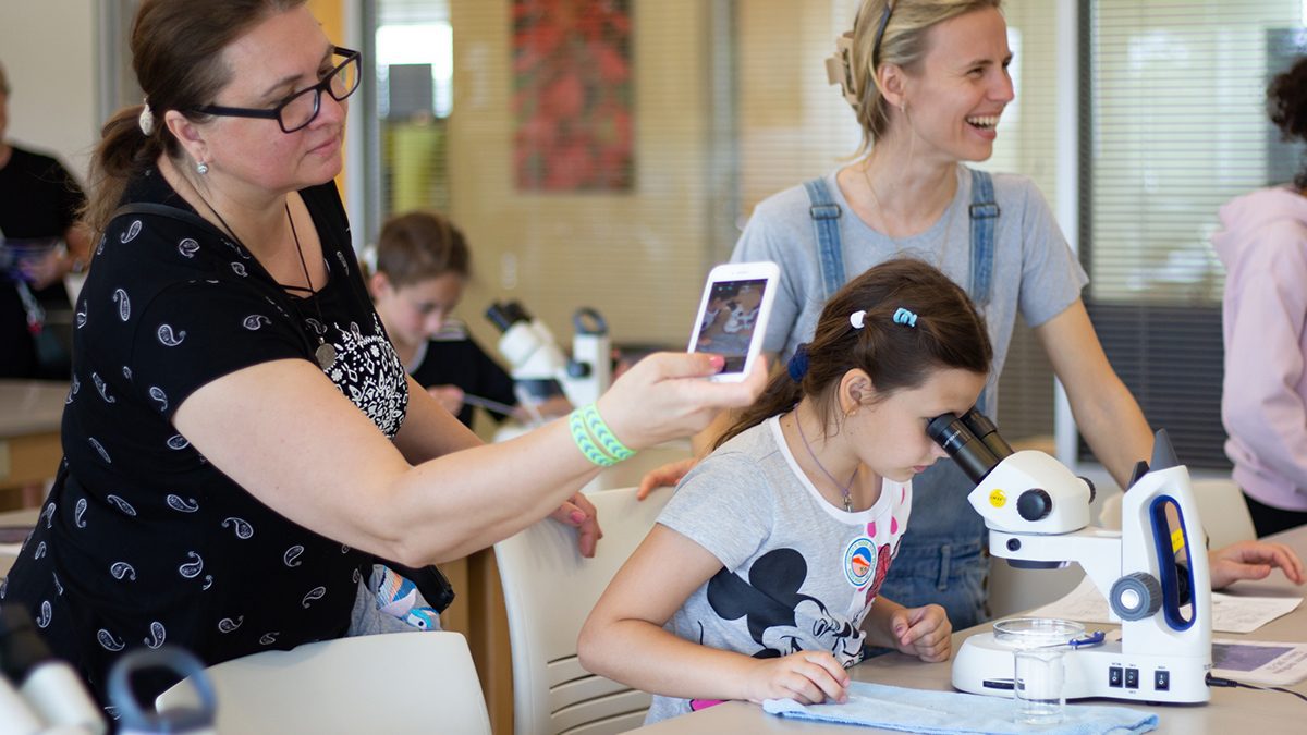 A child looks at plankton through a microscope at the CSI Open House on April 22, with enthusiastic family members nearby. Photo: Corinne Saunders