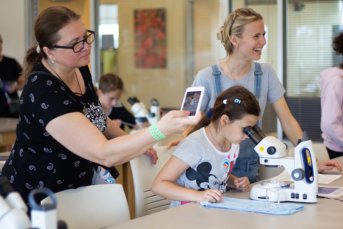 A child looks at plankton through a microscope at the CSI Open House on April 22, with enthusiastic family members nearby. Photo: Corinne Saunders