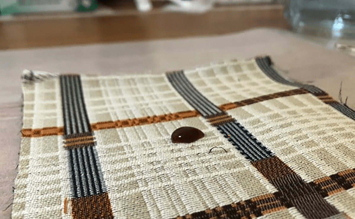 A drop of balsamic vinaigrette is shown on a piece of cotton/nylon fabric. Photo: Green Science Policy Institute