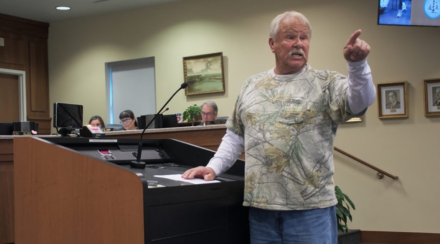 Mitchell Bateman of Wanchese gestures to Brad Alexander, owner of Aria Construction, during the public comment portion of the Dare County Board of Commissioners meeting Monday. Photo: Kip Tabb