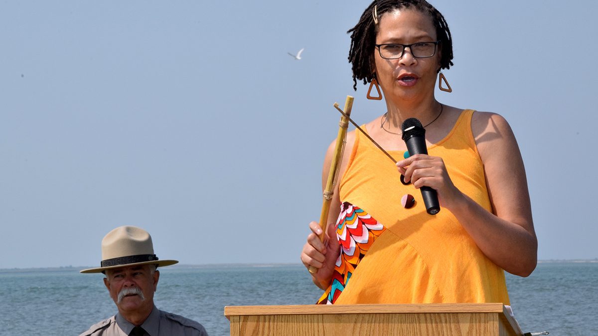 Cape Lookout National Seashore Superintendent Jeff West, left, looks on as Rhonda Jones delivers the invocation Saturday during the Portsmouth Middle Passage marker dedication at Harkers Island. Photo: Mark Hibbs