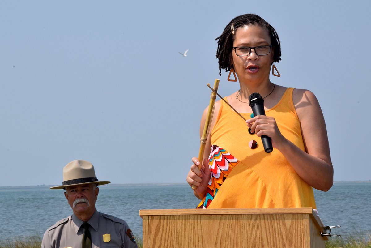 Cape Lookout National Seashore Superintendent Jeff West, left, looks on as Rhonda Jones delivers the invocation Saturday during the Portsmouth Middle Passage marker dedication at Harkers Island. Photo: Mark Hibbs