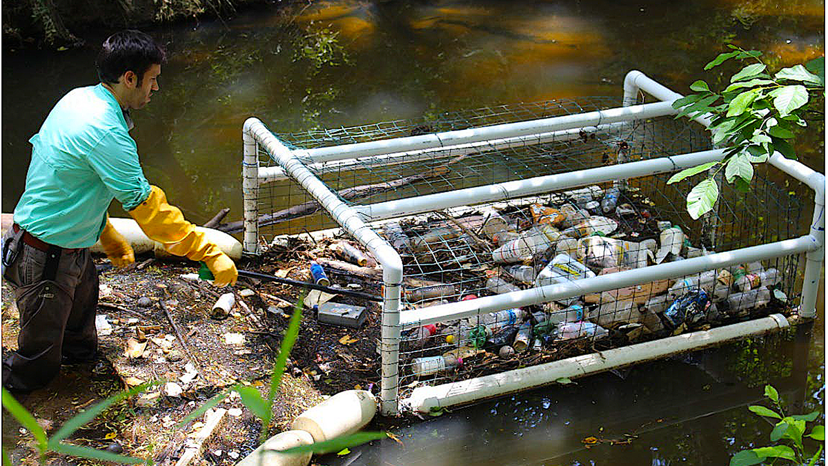 An unidentified man uses a Litter Gitter prototype to remove litter from Marsh Creek after a storm. Photo: North Carolina Sea Grant