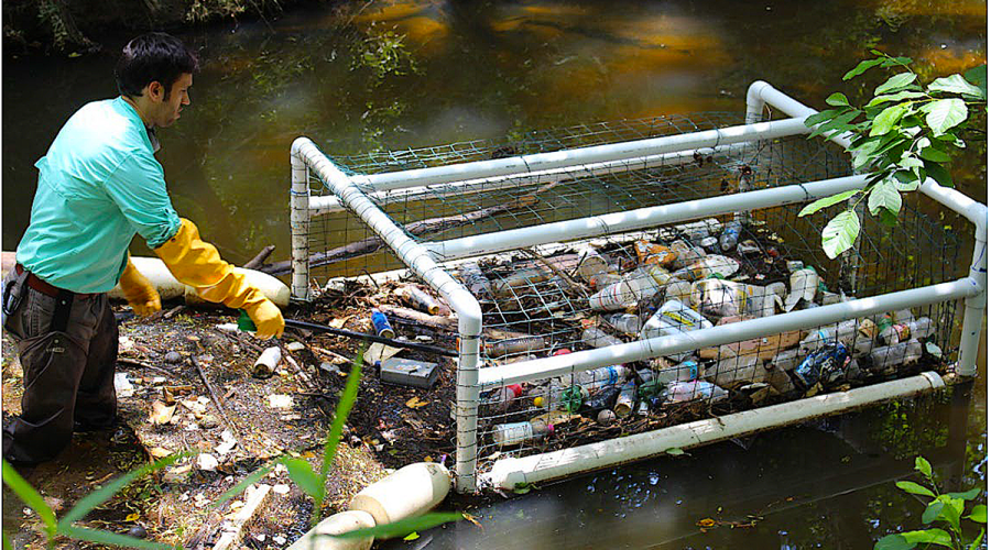 An unidentified man uses a Litter Gitter prototype to remove litter from Marsh Creek after a storm. Photo: North Carolina Sea Grant