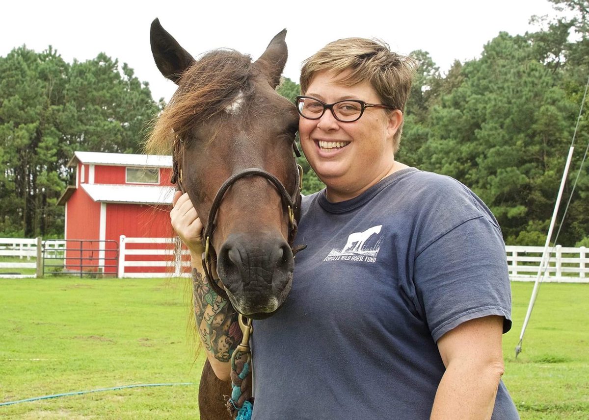 Meg Puckett poses with a horse at the farm where the Corolla Wild Horse Fund cares for sick and injured Banker horses. Photo: Contributed