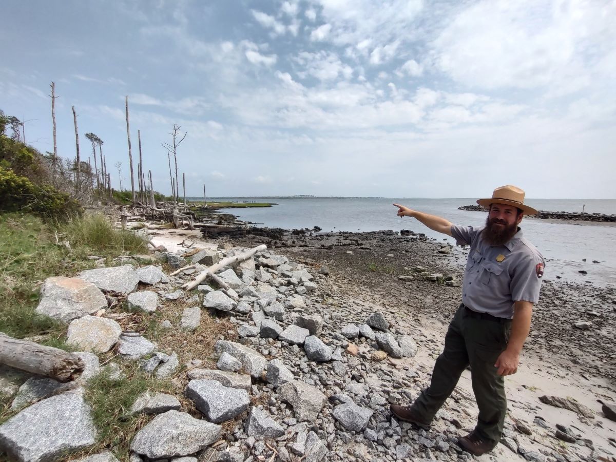 Park Ranger Nate Toering points to the ghost forest that is the focus of the Chronolog photo station at Cape Lookout National Seashore. Photo: Jennifer Allen