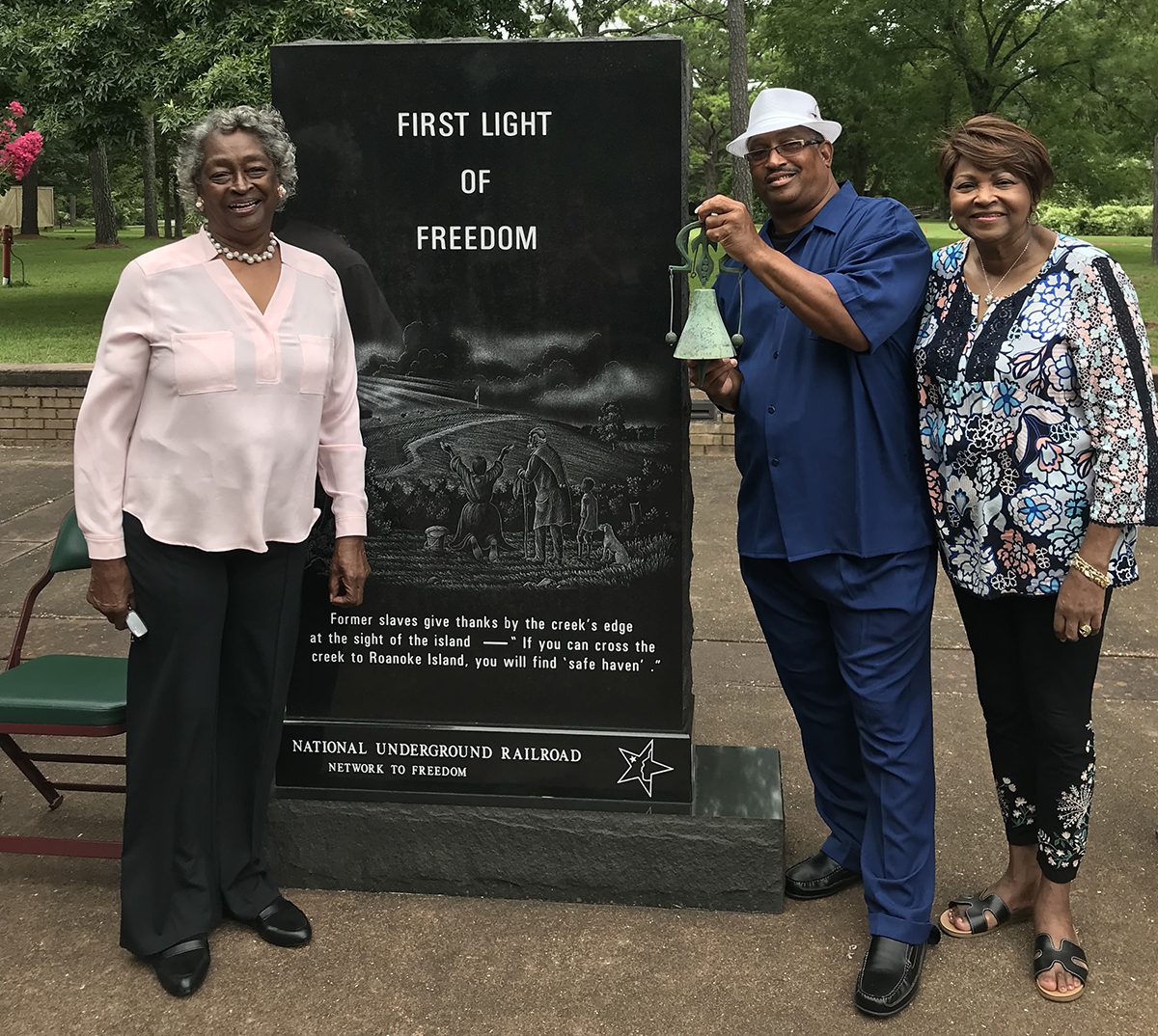The late Virginia Tillett, left, a former Dare County commissioner and a descendant of the colony, poses with family members next to the granite monument at its dedication in 2019. Photo: Catherine Kozak