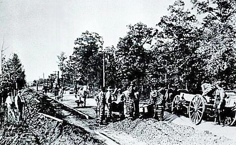 Convicts paving Reynolda Road in Forsyth County, N.C.. A guard with a shotgun or sawed-off rifle is standing on the left. Courtesy, North Carolina Collection, UNC-Chapel Hill
