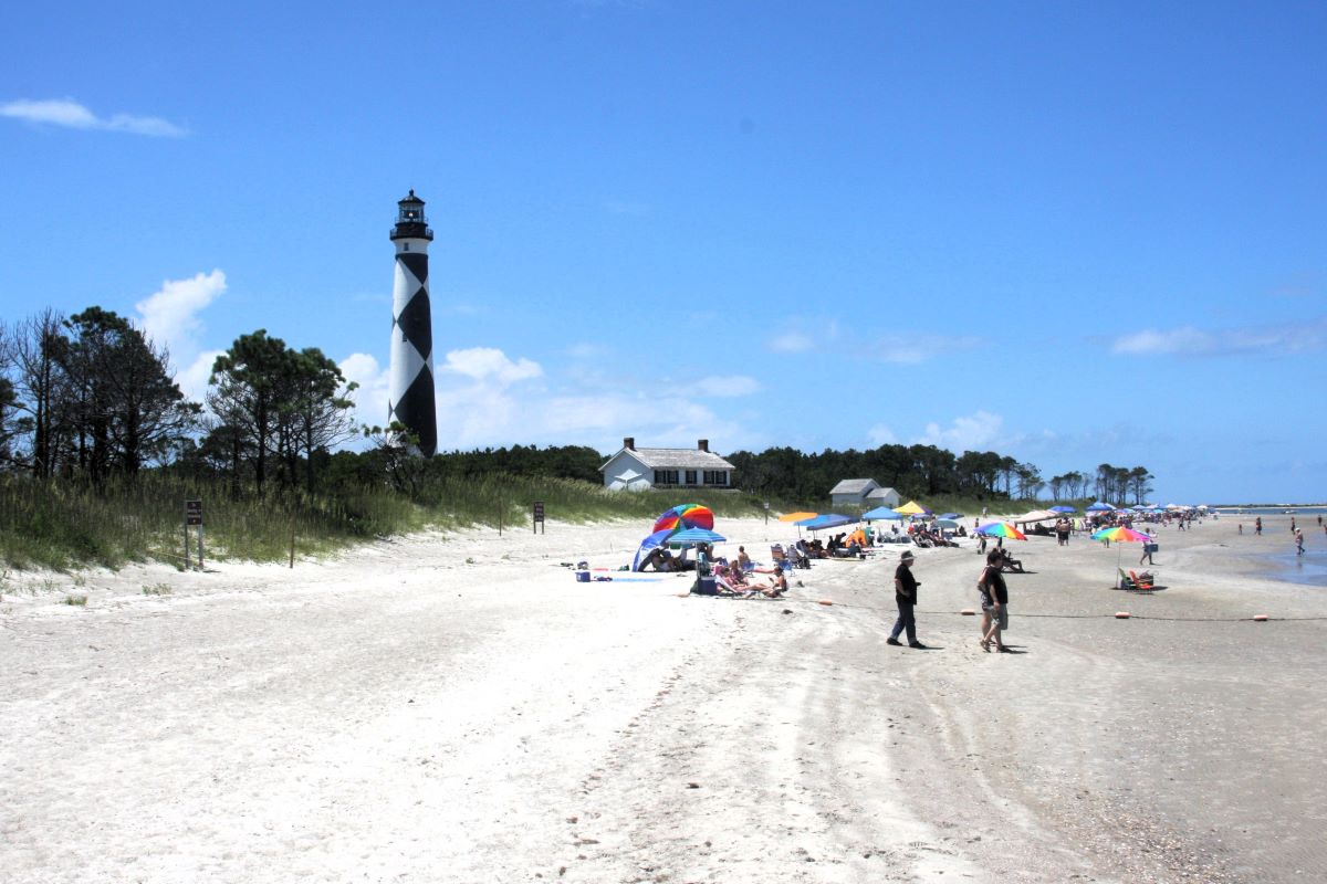 Visitors take in the soundside view under Cape Lookout Lighthouse. Photo: NPS