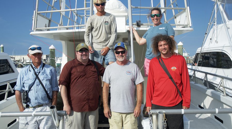 Kate Sutherland, top right, poses with the crew of the Stormy Petrel 2: front row, from left, Jeff Esau, Chris Sloan, Capt. Brian Patteson, Sage Church and, top left, Daniel Irons. Photo: Kip Tabb